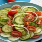 This refreshing cucumber tomato salad made with sliced cucumber, juicy tomatoes, and onion tossed in a sweet and tangy vinaigrette is easy to prepare, has tons of flavor, and is perfect for a warm summer day.